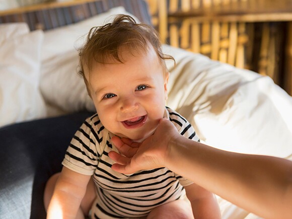 Bebê sorrindo nas mãos da mãe, por Nestlé Baby & Me