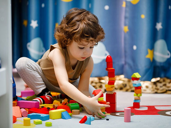 Criança brincando com blocos no chão