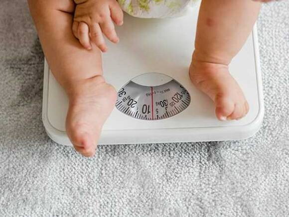 imagem de bebê em cima de uma balança para abordar a obesidade infantil