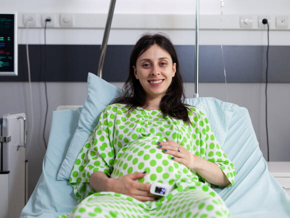 mulher grávida vestindo roupas de hospital