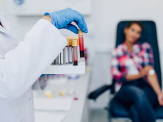 Mulher manuseando tubos de ensaio com amostras de sangue