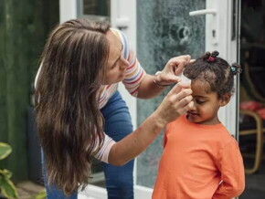 Mãe faz um curativo em criança que bateu a cabeça Mãe faz um curativo em criança que bateu a cabeça