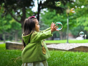 criança brincando com bola de sabão 