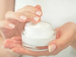 Uma pessoa adulta segurando um pote com um creme hidratante Uma pessoa adulta segurando um pote com um creme hidratante