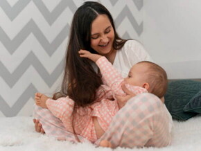 Mãe brincando com seu bebê sorridente em um ambiente acolhedor