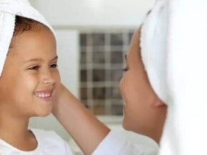 mãe e filha com toalhas na cabeça pós banho