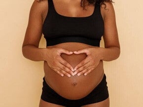 gestante com as mãos formando um coração na barriga. gestante com as mãos formando um coração na barriga.