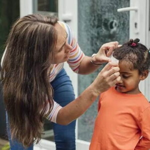 Mãe faz um curativo em criança que bateu a cabeça