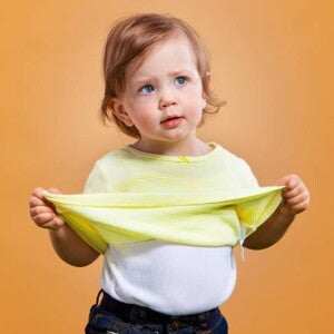 bebe menina de tres anos com blusa amarela no fundo laranja bebe menina de tres anos com blusa amarela no fundo laranja