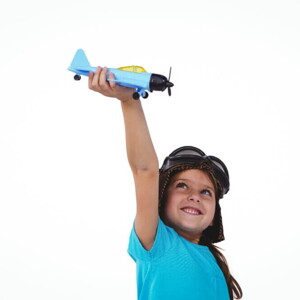 Menina sorrindo e segurando um avião de brinquedo acima da sua cabeça