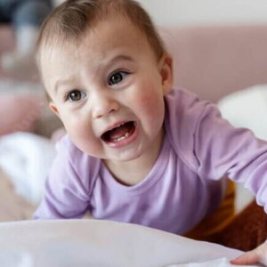 Um bebê engatinhando com a boca aberta.