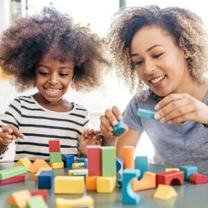Mãe e filha brincam com blocos de montar para favorecer o desenvolvimento infantil