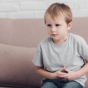 Foto de menino apertando a própria barriga