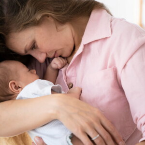Mãe segurando e ninando o filho recém nascido