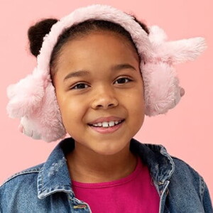 Menina usando jaqueta jeans e protetor de ouvido de pelúcia em frente a uma parede cor de rosa Menina usando jaqueta jeans e protetor de ouvido de pelúcia em frente a uma parede cor de rosa