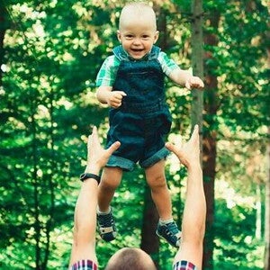 criança brincando com o pai na natureza 