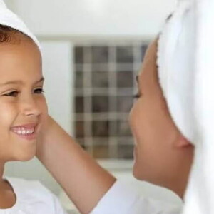 mãe e filha com toalhas na cabeça pós banho