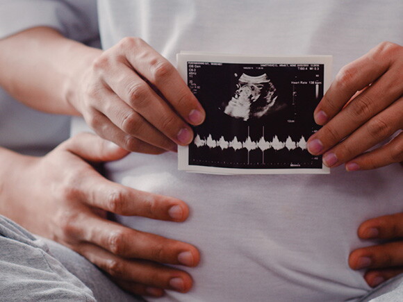 Foto de mãe segurando imagem de ultrassom