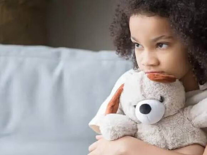 Asperger Imagem de uma criança sozinha segurando um bicho de pelúcia, olhando de forma distraída para o nada, este olhar pode ser um sintoma de síndrome de asperger