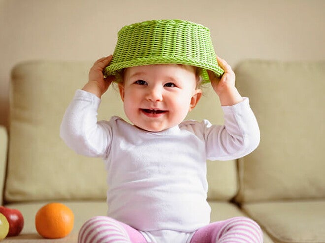 Bebe rindo com cesta na cabeça Bebe rindo com cesta na cabeça