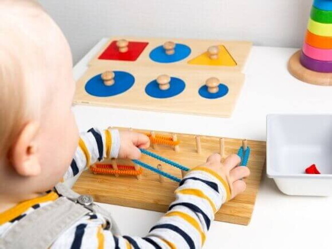 Bebê brincando com objetos lúdicos que trabalham a coordenação motora fina Bebê brincando com objetos lúdicos que trabalham a coordenação motora fina
