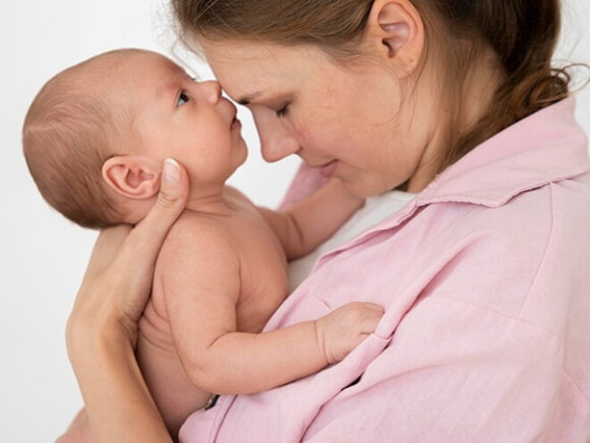 Mulher segurando seu bebê recém-nascido no colo, compartilhando um momento de ternura entre mãe e filho Mulher segurando seu bebê recém-nascido no colo, compartilhando um momento de ternura entre mãe e filho