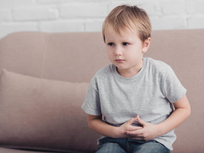 Foto de menino apertando a própria barriga