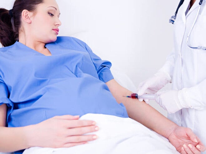 gestante vestindo roupa de hospital, ao lado um profissional de enfermagem colhendo gestante vestindo roupa de hospital, ao lado um profissional de enfermagem colhendo