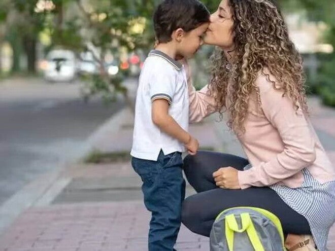 Guarda compartilhada Uma mãe se agacha para se despedir do filho durante a rotina da guarda compartilhada.