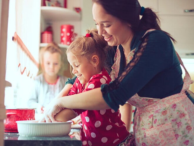 mãe cozinhando com filha 