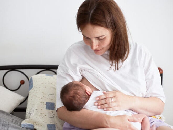 mãe amamenta bebê sentada em cama mãe amamenta bebê sentada em cama