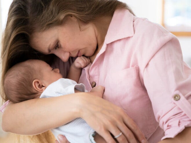 Mãe segurando e ninando o filho recém nascido