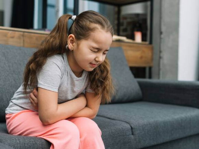 menina com esofagite com os braços cruzados na barriga sofrendo de dor abdominal menina com esofagite com os braços cruzados na barriga sofrendo de dor abdominal