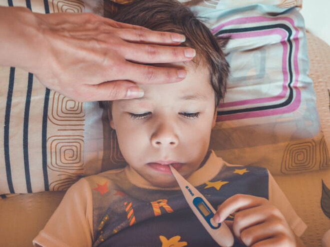 menino com febre com os olhos fechados e termômetro na boca menino com febre com os olhos fechados e termômetro na boca