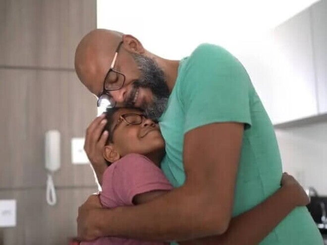 O que é parentalidade? Estamos fazendo do jeito certo? Exercendo a parentalidade positiva, pai abraça filho, dentro de casa.
