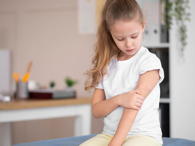 Uma criança sentada em um sofá segurando o braço Uma criança sentada em um sofá segurando o braço