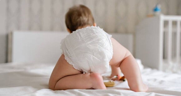 bebê de costas engatinhando sobre uma cama bebê de costas engatinhando sobre uma cama