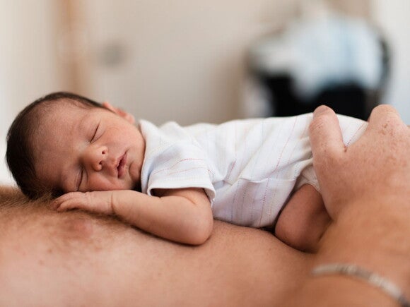 O que fazer para o recém-nascido dormir melhor? Bebê dormindo na barriga do pai