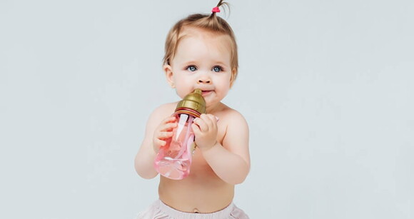 Bebê de olhos azuis com mamadeira na boca. Bebê de olhos azuis com mamadeira na boca.
