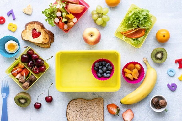  Imagem de uma superfície com frutas, legumes e pães espalhados sobre a mesma