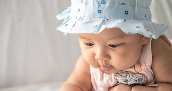 Bebê com roupa roupa e chapéu azul em um fundo branco e neutro Bebê com roupa roupa e chapéu azul em um fundo branco e neutro