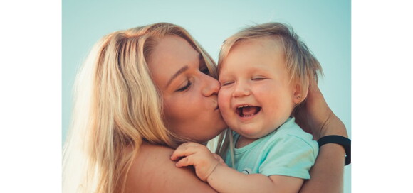 Mãe abraça e beija filho bebê