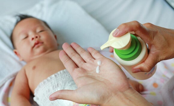 Mãe indo aplicar pomada em bebê Mãe indo aplicar pomada em bebê