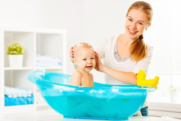 mulher adulta dando banho em um bebê na banheira mulher adulta dando banho em um bebê na banheira