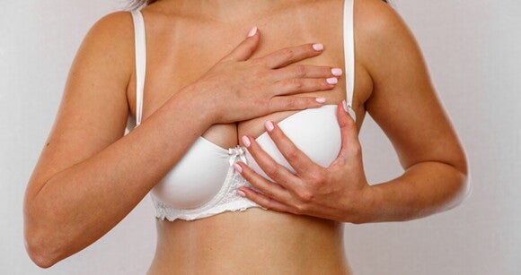 Mulher com candidíase mamária apalpando os seios Mulher com candidíase mamária apalpando os seios
