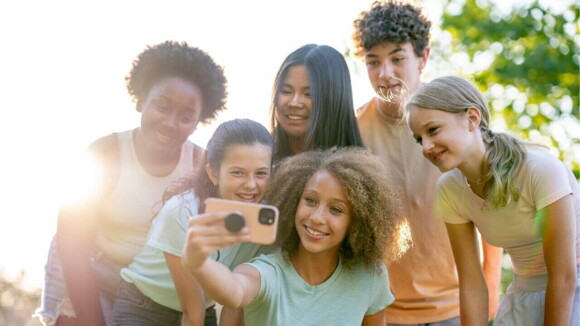 Um grupo de jovens sorrindo e fazendo pose para uma selfie Um grupo de jovens sorrindo e fazendo pose para uma selfie