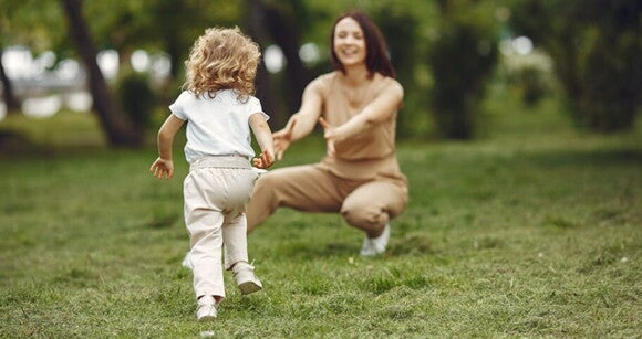 Uma mulher e uma criança brincando alegremente ao ar livre Uma mulher e uma criança brincando alegremente ao ar livre