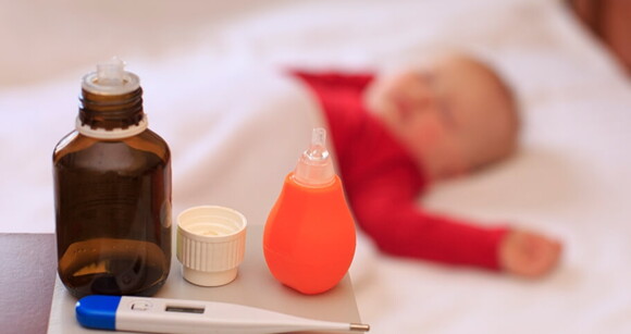 Bebê deitado no berço enquanto sua mãe prepara sua medicação. Bebê deitado no berço enquanto sua mãe prepara sua medicação.